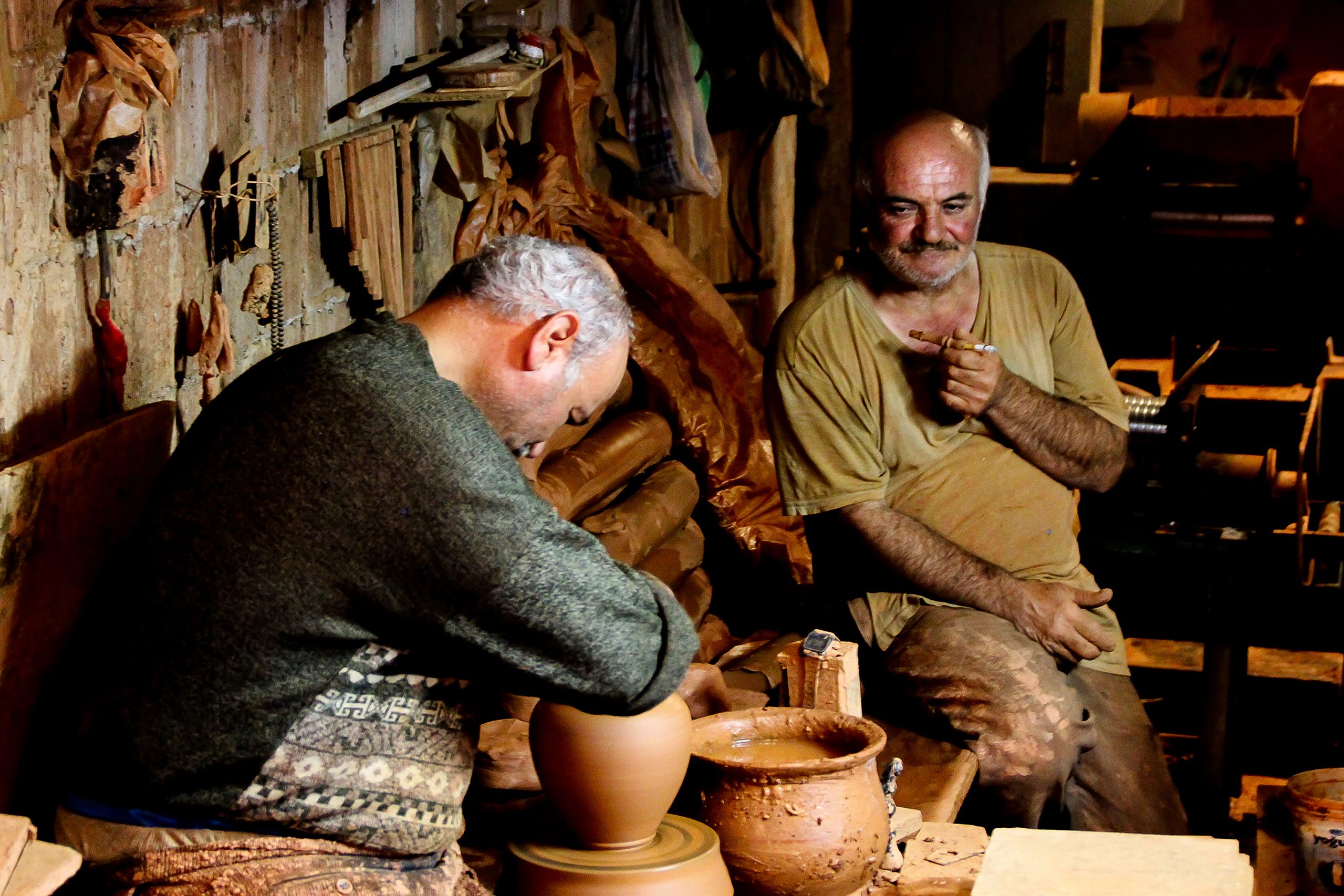 Two artisans working at pottery wheels