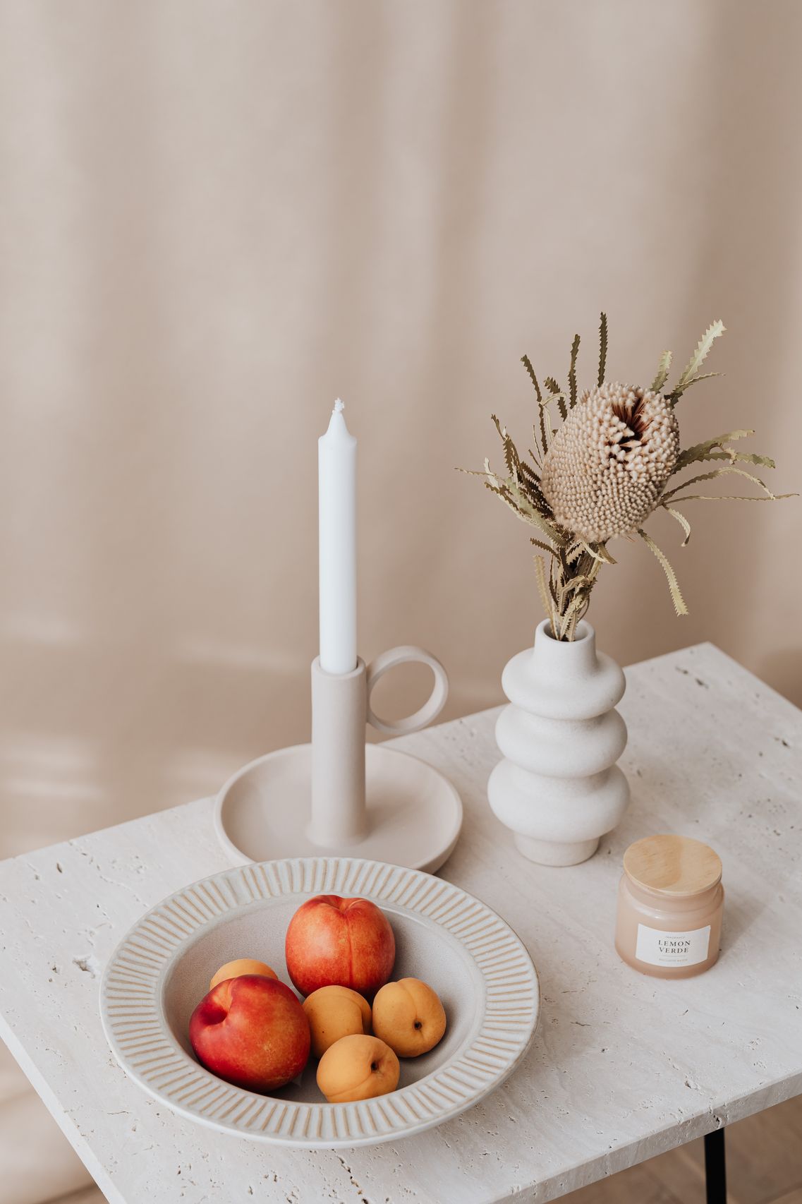 Tall beige vase with dried flowers, mug and bowl on table